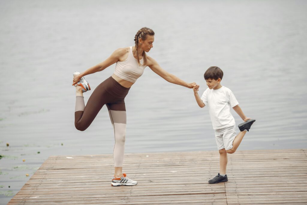 Mother and Son Practising Yoga on a Pier